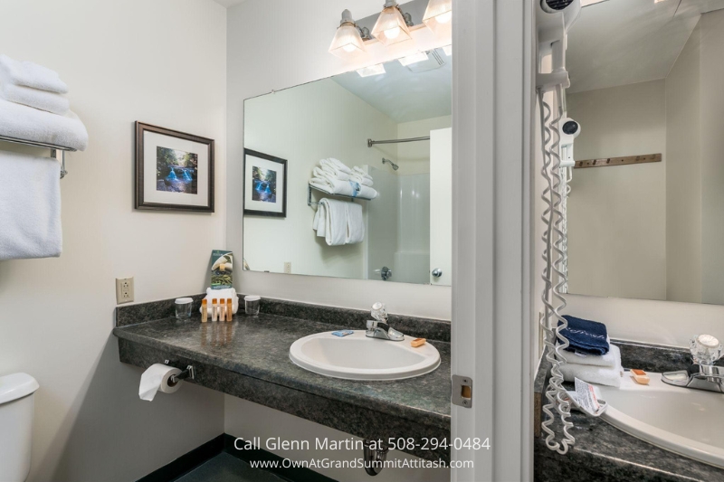 a bathroom with a sink, toilet, and mirror