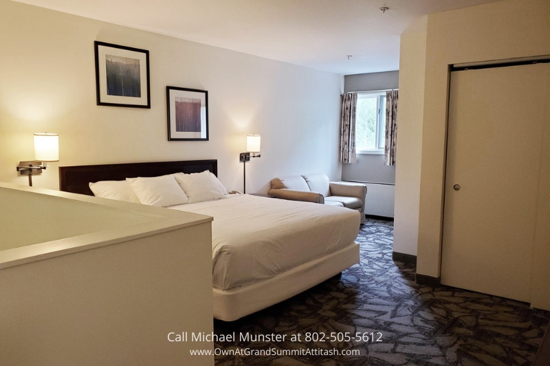 Inviting bedroom in the Grand Summit Hotel with a cozy king-sized bed, soft lighting, and stylish decor, providing guests with a peaceful and relaxing environment for a good night's sleep.