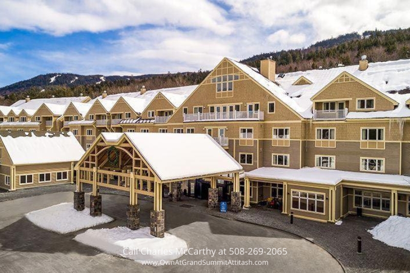 Front entrance of the Grand Summit Hotel will be open during winter, showcasing its charming mountain lodge design with snow-capped roofs and a welcoming porte-cochère.