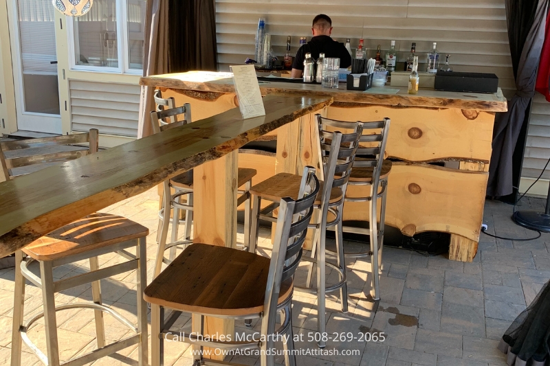 Rustic bar area at the Grand Summit Hotel, featuring a handcrafted wooden countertop and comfortable seating, ideal for enjoying a drink in a relaxed atmosphere.