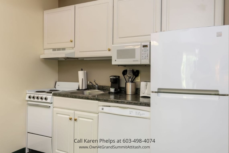 Fully equipped kitchen in Unit 149 Interval 3 with white cabinetry, refrigerator, stove, microwave, and countertop appliances for convenient meals