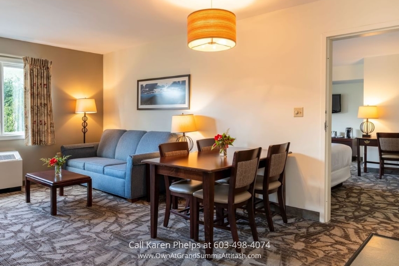Comfortable living and dining area in Unit 149 Interval 3 with a blue couch, dining table for four, and warm lighting for a homey retreat
