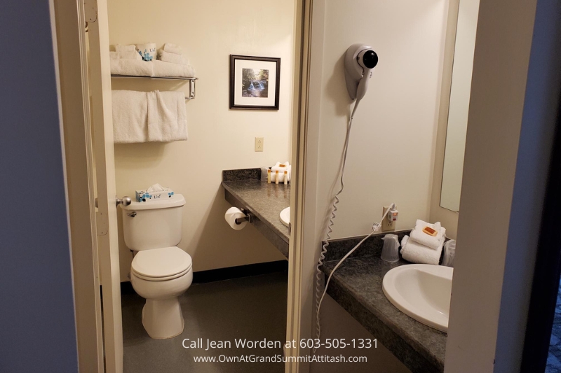 Bathroom in a Bartlett NH Resort Living Unit, featuring a clean and minimalist design with a toilet, sink, and neatly arranged towels, providing a comfortable and functional space.