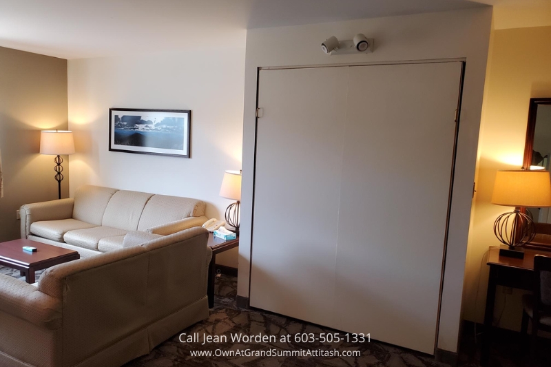 Standard hotel room in the Bartlett NH Resort Living Unit, featuring a neatly made bed, a comfortable sitting area, and soft lighting that adds a warm atmosphere for guests.